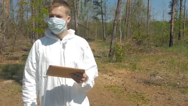 Homem Uniforme Branco Máscara Usando Tablet Digital Floresta Dia Ensolarado — Vídeo de Stock