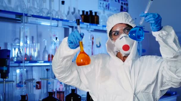 白色制服 面具和蓝色手套的年轻妇女在现代实验室工作与试管 — 图库视频影像