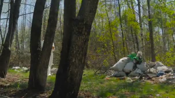 Hombre Uniforme Blanco Caminando Bosque Lleno Basura Día Soleado — Vídeo de stock