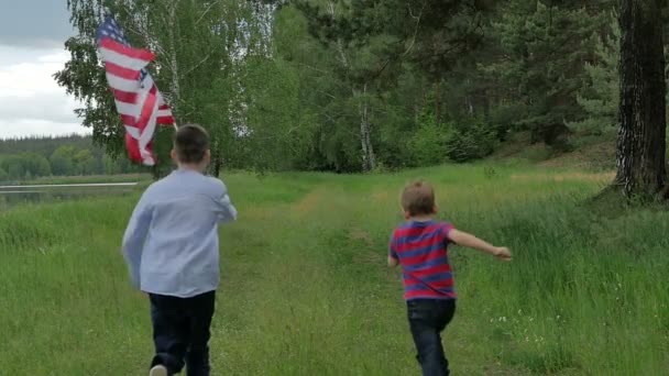 Niedlichen Jungen Mit Amerikanischer Flagge Und Läuft Grünen Wald Draußen — Stockvideo