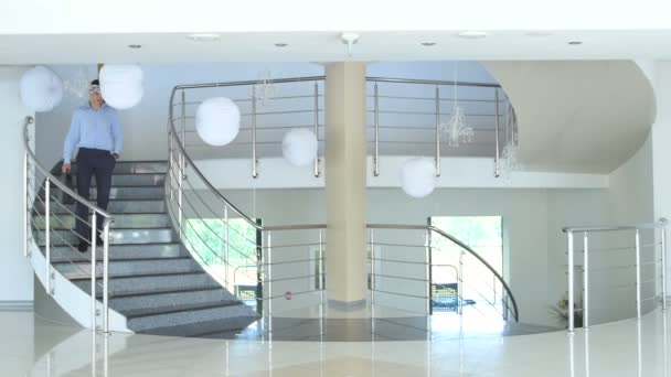 近代的なオフィスビルの階段に若いビジネスマン — ストック動画