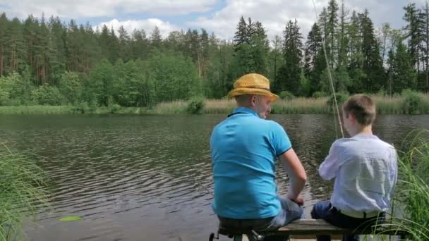 男子在绿色公园湖捕鱼男孩 — 图库视频影像