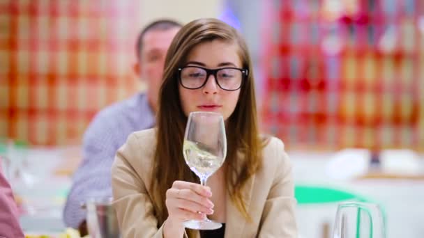 ワインのテイスティング グラスで白ワインを移動ブルネットの女性のクローズ アップ — ストック動画
