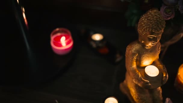 svíčky a sochy Buddhy v tradičním thajském spa salonu