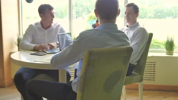 Jóvenes Hombres Negocios Hablando Trabajando Con Ordenador Portátil Mesa Redonda — Vídeos de Stock