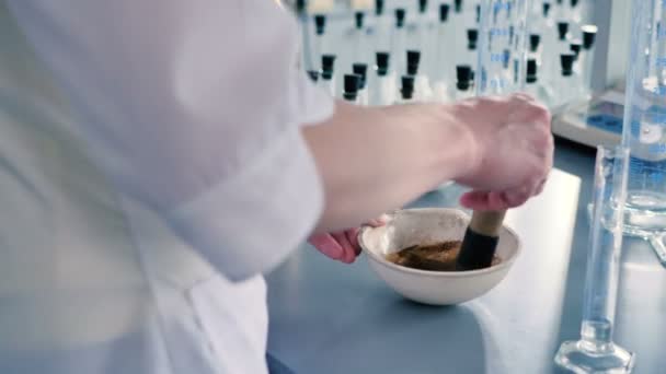 白色均匀混合草药在现代实验室白瓷碗的妇女 — 图库视频影像