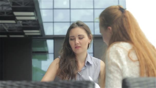 在现代建筑背景下 年轻的商界女性一起在户外咖啡馆工作 — 图库视频影像