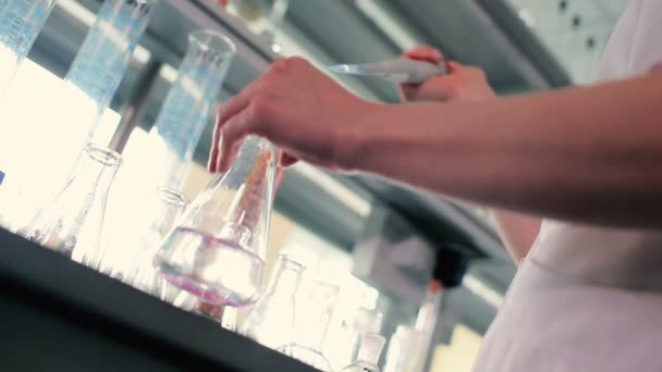 穿着白色制服的妇女在现代实验室中使用试管 — 图库视频影像