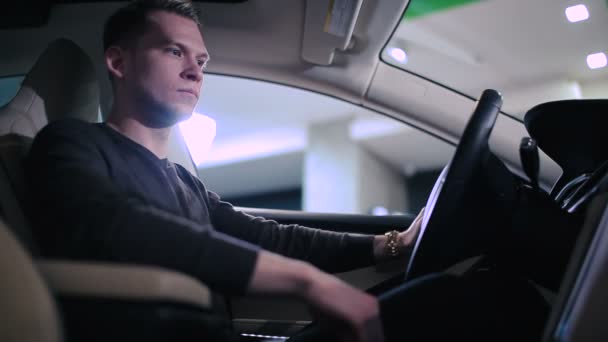 クローズ アップ現代の新車で黒のセーターで若いハンサムな男の — ストック動画