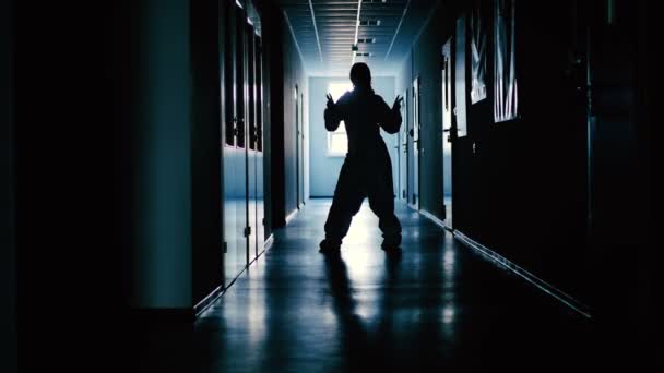 silhouette féminine dans la danse uniforme de protection dans le hall du laboratoire  