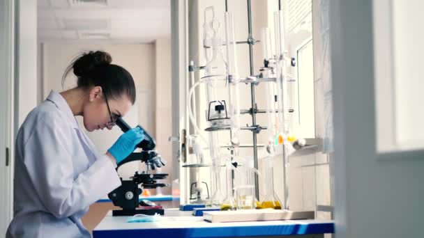 白い制服の近代的な研究室での作業で若いブルネットの女性 — ストック動画