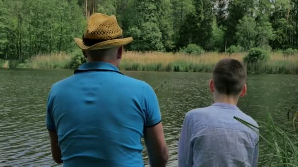 男子在绿色公园湖捕鱼男孩 — 图库视频影像