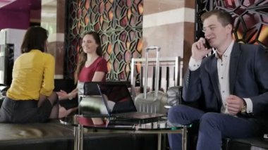 Telefonunuzun ve divan arka plan üzerinde iş kadınları ile işadamı