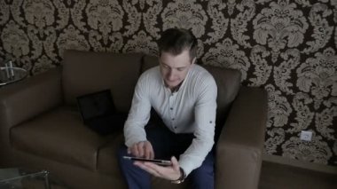 işadamı kanepede oturan ve dijital tablet odasında kullanma gömlekli 