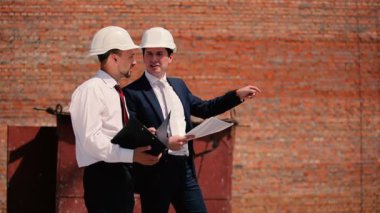 İşadamları kask bick duvar içinde 