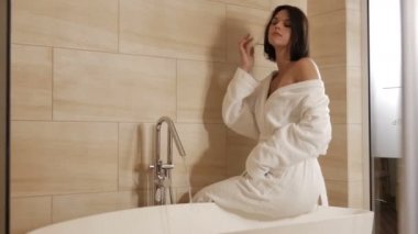 esmer kadın banyoda evde beyaz elbise içinde