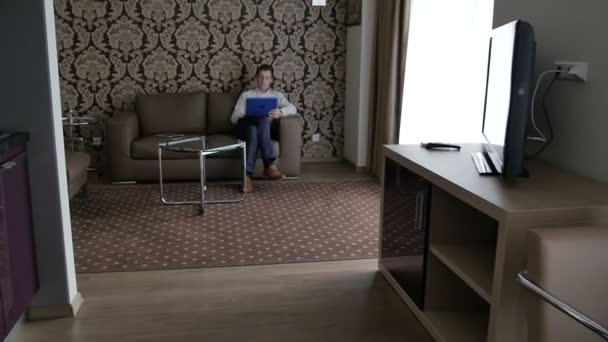 穿着衬衫的商人坐在沙发上 在房间里使用笔记本电脑 — 图库视频影像