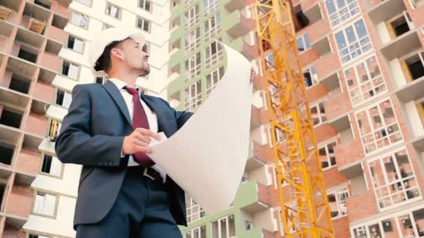 Businessman in helmet on buildings construction — Stock Video