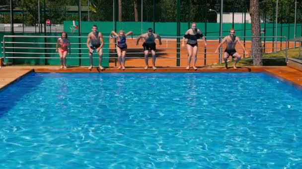 Pessoas saltam na piscina — Vídeo de Stock