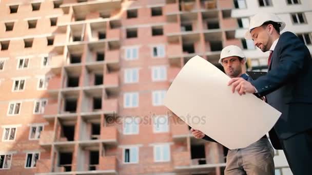 İşadamları binalar inşaat kask içinde — Stok video