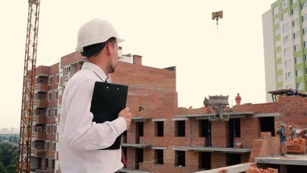 Бизнесмен в шлеме с помощью телефона — стоковое видео