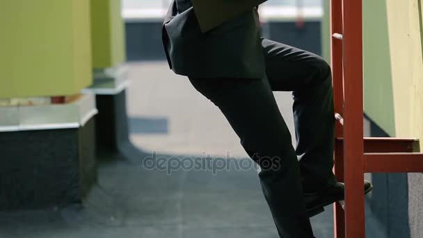 Hombre de negocios en traje usando escalera — Vídeos de Stock