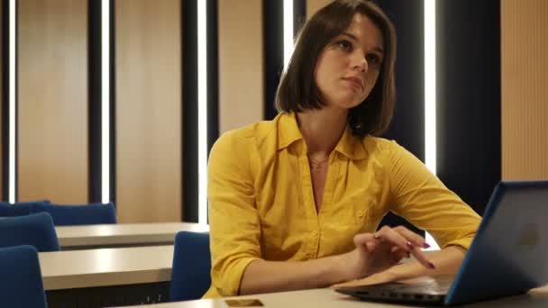 黄色のシャツがノート パソコンで作業のブルネットの女性実業家 — ストック動画