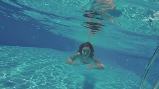 Mujer nadando bajo el agua en la piscina — Vídeo de stock