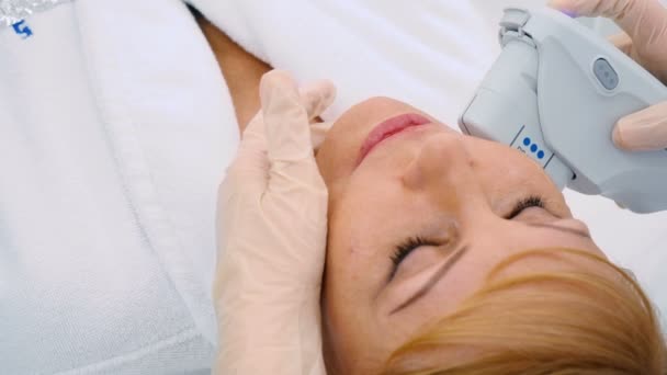 美容クリニックで金髪の中高齢者女性の医者のきれいな顔 — ストック動画