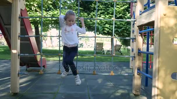 Schattig klein meisje in de tuin spelen — Stockvideo