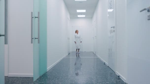 Blond Kobieta Średnim Wieku Białą Szatę Chodzenie Klinice Nowoczesnej Kosmetologii — Wideo stockowe