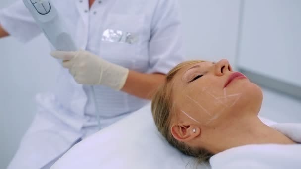 Врач Очищает Лицо Блондинки Среднего Возраста Косметологической Клинике — стоковое видео