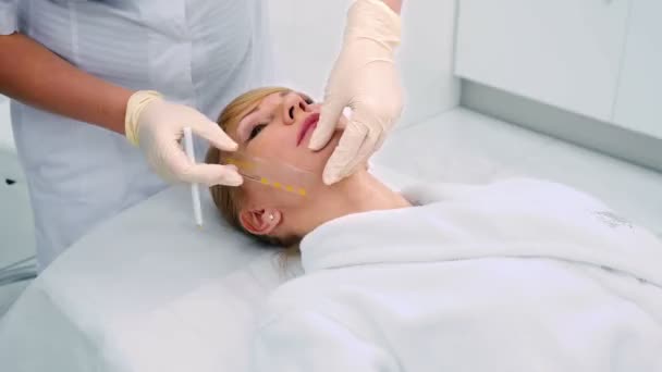 Läkare Använder Pennan Ansiktet Blond Mellersta Åldern Kvinnliga Kosmetologi Klinik — Stockvideo