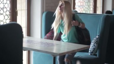 Telefonunuzun ve kafede mavi gömlekli sarışın genç kadın