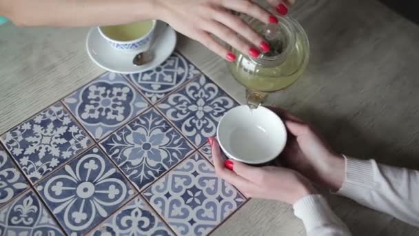 カフェのカップで緑茶を注いで手を女性のクローズ アップ — ストック動画