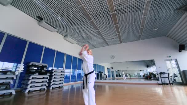 Mujer joven practicando karate en el gimnasio — Vídeos de Stock