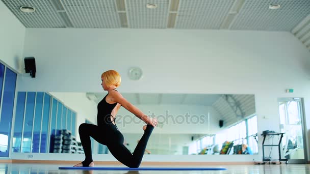 Rothaarige Frau in Sportbekleidung praktiziert Yoga — Stockvideo