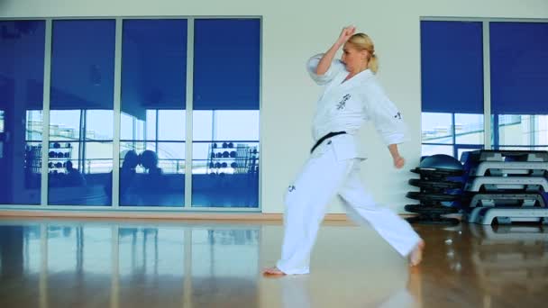 Mujer practicando karate en gimnasio — Vídeos de Stock