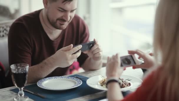 年轻的金发女子穿着红色的衣服 男人在咖啡馆里用手机 — 图库视频影像