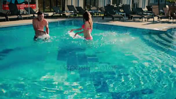 Hrát žena s mužem ve venkovním bazénu — Stock video