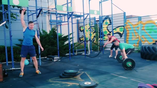 Мышечные мужчины тренировки в открытом тренажерном зале — стоковое видео
