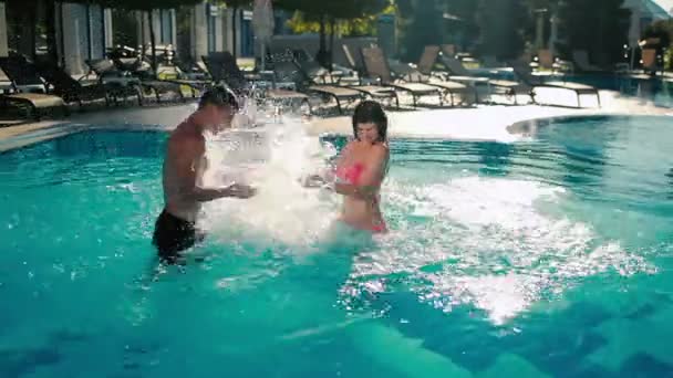 Woman play with man in outdoor pool — Stock Video