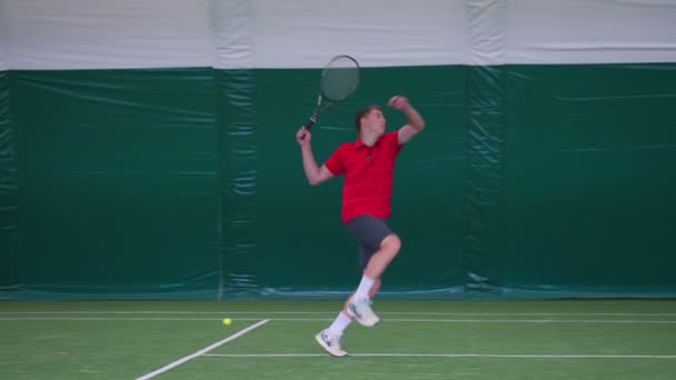 Чоловік у червоній сорочці грає в теніс — стокове відео