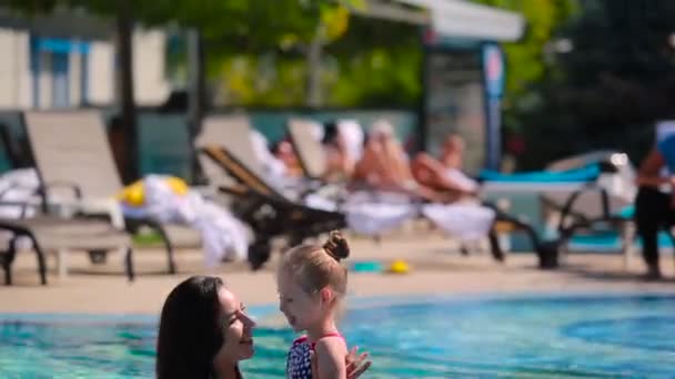 Mulher com menina na piscina exterior — Vídeo de Stock