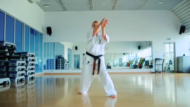 Mujer joven practicando karate en el gimnasio — Vídeo de stock