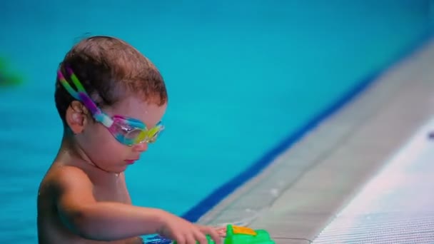 Junge mit Schutzbrille schwimmt im Pool. — Stockvideo