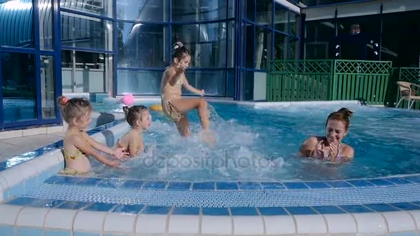 Chicas salpicando mujer en la piscina — Vídeo de stock