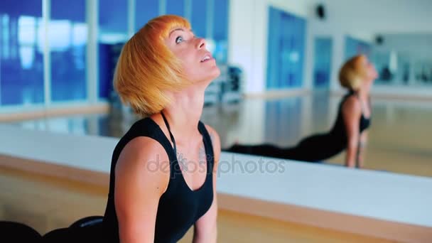 Mujer practicando yoga en clase de gimnasia — Vídeos de Stock