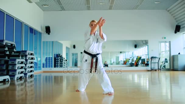 Blondine übt Karate im Fitnessstudio — Stockvideo