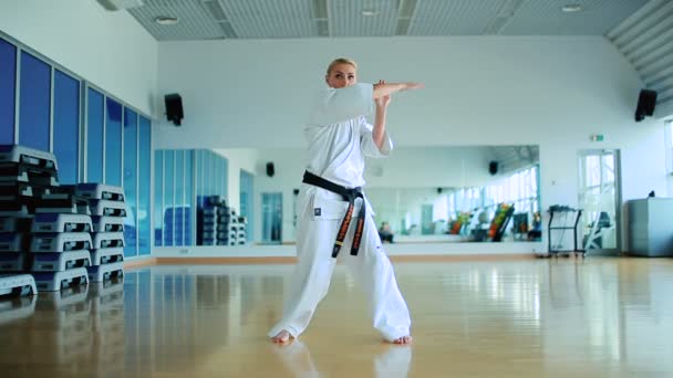 Szőke nő gyakorolják a karate, a tornaterem — Stock videók